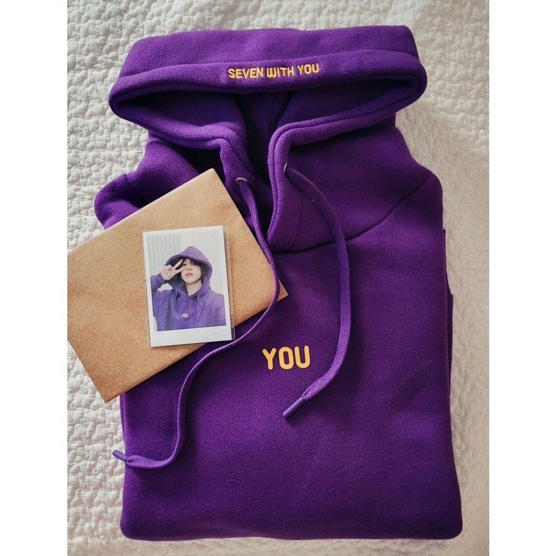 Purple hoodie front with yellow YOU lettering and Seven With You hood detail
